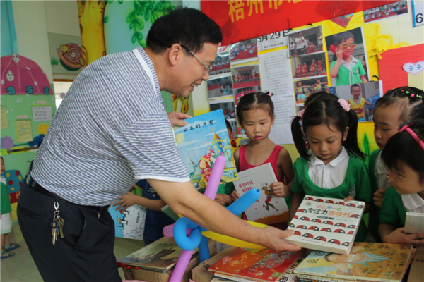 梧州市總工會黨組書記、常務副主席朱明勝在梧州市總工會到梧州高新區(qū)雙語實驗學校開展關愛農民工留守活動中為孩子們送上學習用具